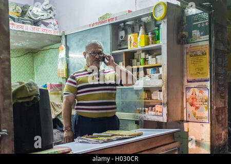 JODHPUR, INDIA - 16 FEBRUARY 2015: Local pharmacists talks on cell-phone before closing time. Stock Photo