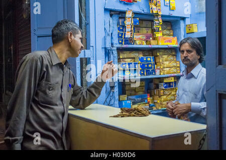 JODHPUR, INDIA - 16 FEBRUARY 2015: Indian vendor sells gutka to customer. Gutka has mild stimulant effect and is consumed by suc Stock Photo