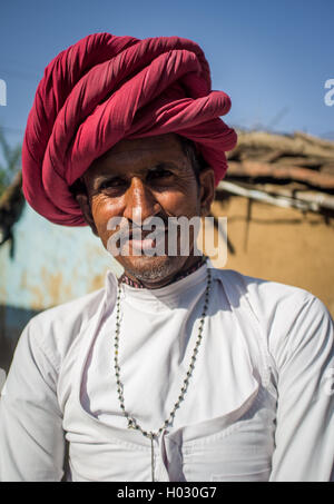 GODWAR REGION, INDIA - 13 FEBRUARY 2015: Rabari tribesman stands in courtyard of home wearing traditional clothes. Rabari or Rew Stock Photo