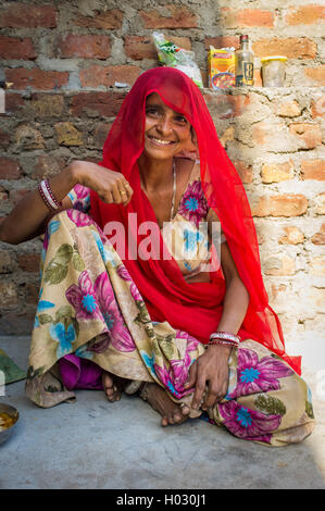 GODWAR REGION, INDIA - 13 FEBRUARY 2015: Indian woman in sari sits next to brick wall. Stock Photo