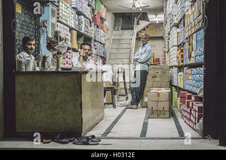 JODHPUR, INDIA - 16 FEBRUARY 2015: Three Indian men in textile store. Post-processed with grain and texture. Stock Photo