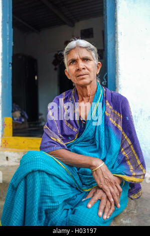 HAMPI, INDIA - 31 JANUARY 2015: Elderly Indian woman sitting in a sari infront of her home Stock Photo