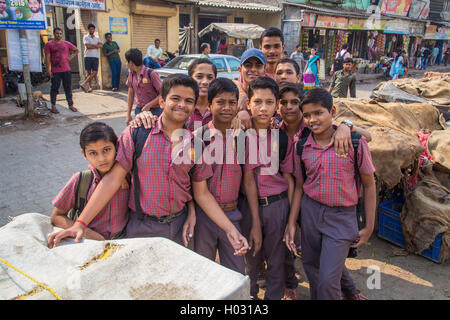 MUMBAI, INDIA - 16 JANUARY 2015: Schoolboys dressed in uniform gather around for a photograph in slum street. Stock Photo