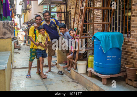 MUMBAI, INDIA - 16 JANUARY 2015: Father and sons stand together in slum street. Stock Photo