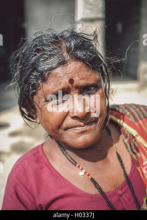 HAMPI, INDIA - 01 FEBRUARY 2015: Indian middle-aged woman with bindi on street in-front of home. Post-processed with grain, text Stock Photo