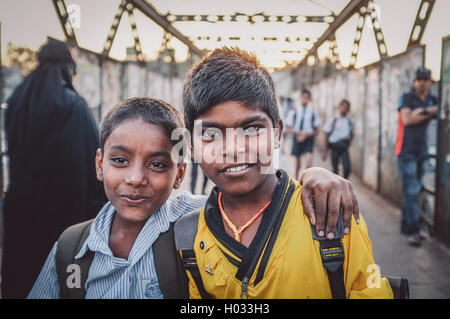 MUMBAI, INDIA - 12 JANUARY 2015: Indian school boys on bridge in Dharavi slum. Post-processed with grain, texture and colour eff Stock Photo