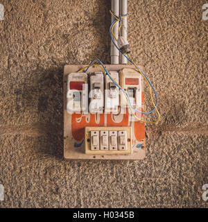 HAMPI, INDIA - 28 JANUARY 2015: Small safety fuse with switches on stone wall. Post-processed with grain, texture and colour eff Stock Photo
