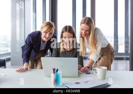 Three business women in modern office working on the project together. Stock Photo