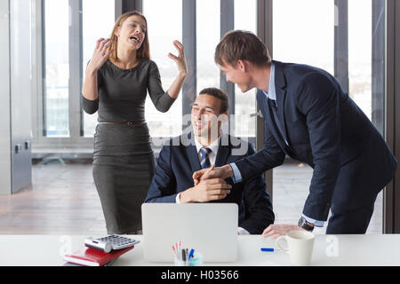 Excited business people in modern office working on project. Stock Photo
