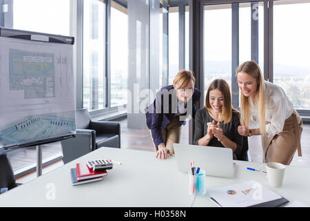 Three business women in modern office working on the project together. Stock Photo