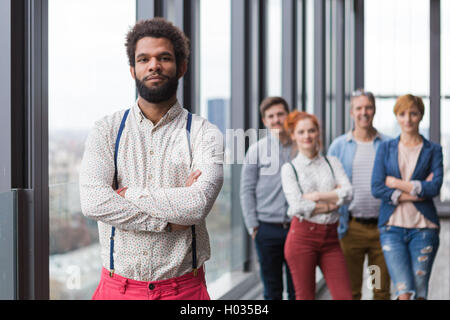 Corporate portrait of young black hipster businessman with his colleagues in background. Stock Photo