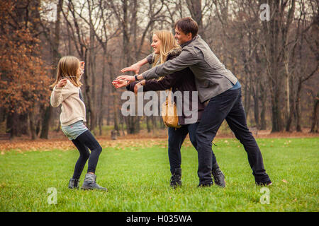 ZAGREB, CROATIA - 15 NOVEMBER 2015: Family of three play around in park. Stock Photo