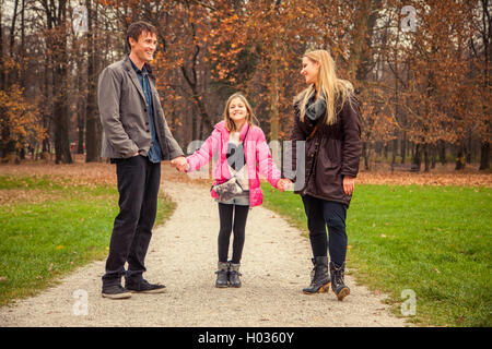 ZAGREB, CROATIA - 15 NOVEMBER 2015: Family of three stand next to each other in park. Stock Photo