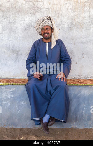 DARAW, EGYPT - FEBRUARY 6, 2016: Local camel salesman holding glass. Stock Photo