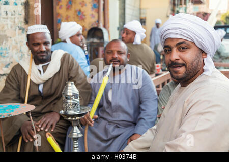 DARAW, EGYPT - FEBRUARY 6, 2016: Local men smoking shisha pipe at Daraw market. Stock Photo