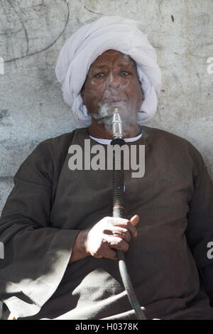 DARAW, EGYPT - FEBRUARY 6, 2016: Portrait of kocal camel salesman smoking shisha pipe. Stock Photo