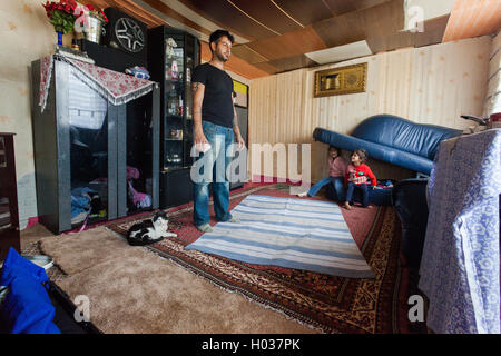 ZAGREB, CROATIA - OCTOBER 21, 2013: Roma man and his daughters at their home. Stock Photo