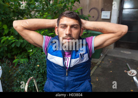 ZAGREB, CROATIA - OCTOBER 15, 2013: Young Roma man sitting on a bicycle and posing for camera at garbage dump. Stock Photo