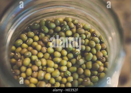 Mason jar of mung beans purchased in bulk from whole food and placed in trendy glass jar to avoid plastic. Stock Photo
