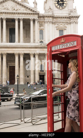 St Paul's Cathedral, girl exiting telephone box Stock Photo
