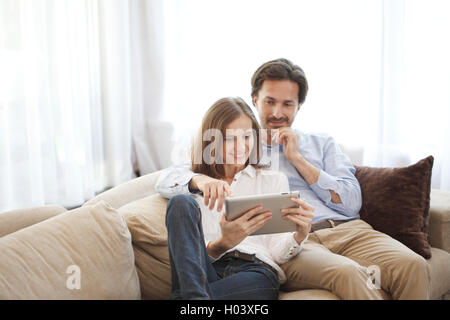Cheerful couple using digital tablet at home Stock Photo