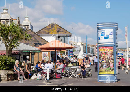 People dining in sunshine outside a pavement cafe ice cream parlour on Weymouth seafront promenade. Melcombe Regis Weymouth Dorset England UK Britain Stock Photo