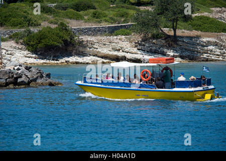 A small excursion boat full of tourists returning from Anti Paxos to Gaios harbour on the Greek island of Paxos. Stock Photo