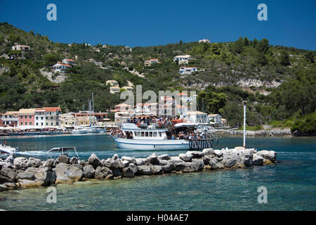 An escursion boat full of tourist going into Gaios harbour on the island of Paxos, The Ionian Islands, The Greek Islands, Greece Stock Photo