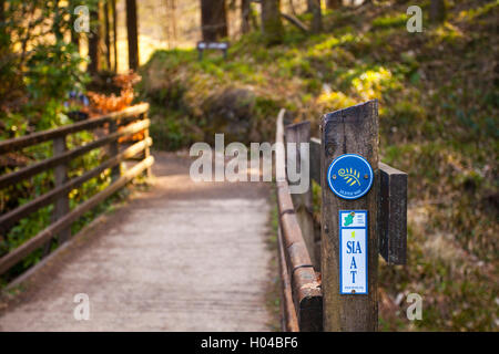 Small sign indicating the Ulster Way on a pathway through Glenariff Forest Park, Co. Antrim, Northern Ireland. Glenariff is one Stock Photo