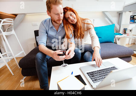 Beautiful business couple working on laptop in  modern cosy room Stock Photo