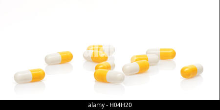 Pile of yellow and white capsules isolated on white background. Clipping path included. Stock Photo
