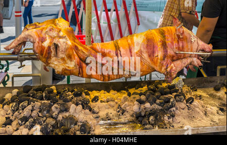 Whole pig roasting on a spit in the Naschmarkt, Linke Wienseile, Vienna, Austria Stock Photo