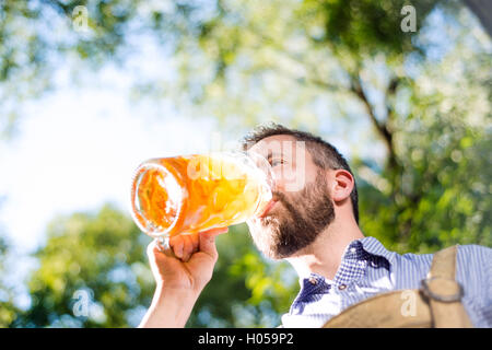 Man in traditional bavarian clothes holding mug of beer Stock Photo