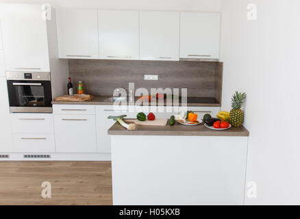 Modern kitchen with appliances. White kitchen with wooden elements. Stock Photo