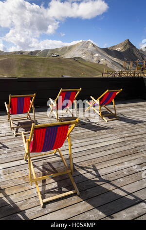 Colorful empty deckchairs on terrace with Italian Alps mountains view Stock Photo