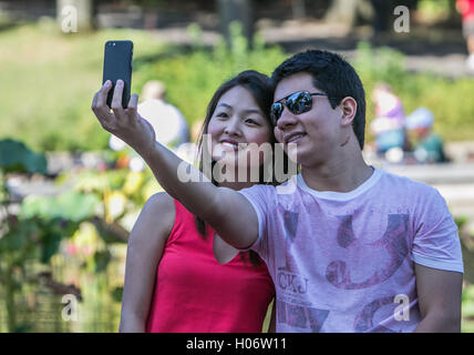 A young couple is taking a selfie in Central Park. Stock Photo