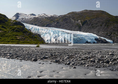 A muddy stream flows across the image with Portage Glacier in the background. Stock Photo