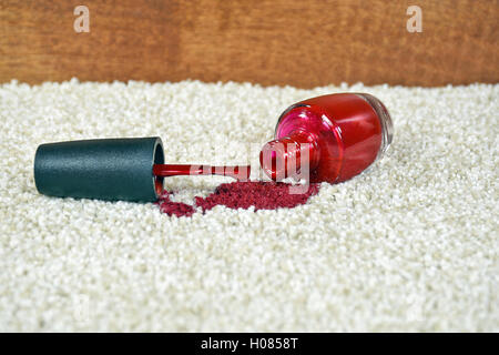Bright red nail polish spilled on light colored carpet Stock Photo