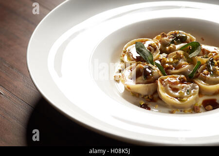 Handcrafted agnolotti on white dish Stock Photo