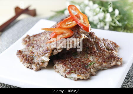 Grilled meat on white plate with sliced chili Stock Photo