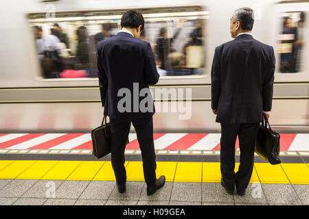 Two businessmen waiting for a train on the Tokyo Metro, Tokyo, Japan, Asia Stock Photo