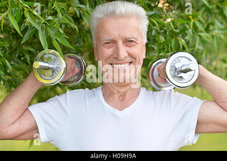 Elderly man exercising with dumbbells Stock Photo