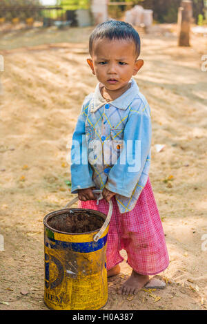 Local child, boy with an old bucket, Bagan, Mandalay Region, Myanmar Stock Photo