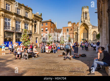 Crowds watching one man band busking in St Helen's Square, York, North Yorkshire, England, UK Stock Photo