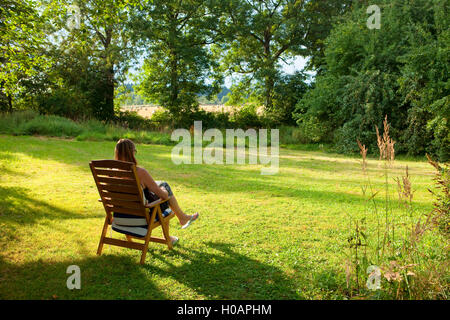 Woman Reading a Book in the Garden Stock Photo