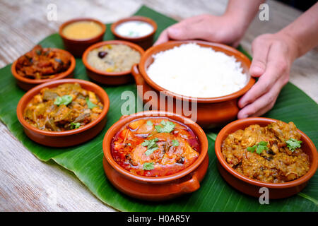 Indian meal with braised pork, curry and plain rice on banana leaf tray Stock Photo