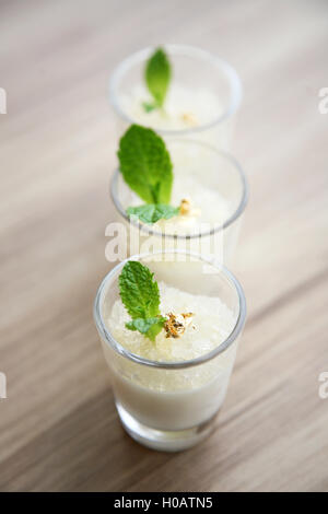 Milk pudding with fish maws and mint leaf in glasses Stock Photo