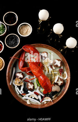 Red steamed lobster with mushroom in plate on black background Stock Photo