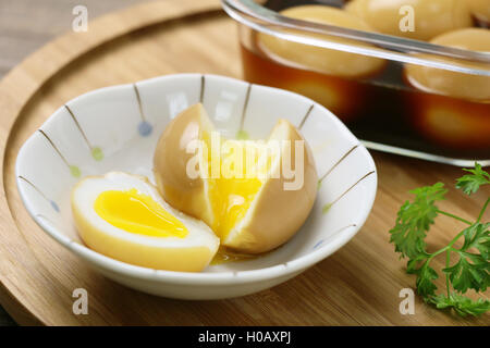 Runny eggs on white bowl with braised eggs on wooden table Stock Photo