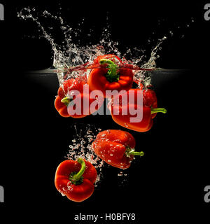 Group of bell pepper falling in water on black Stock Photo